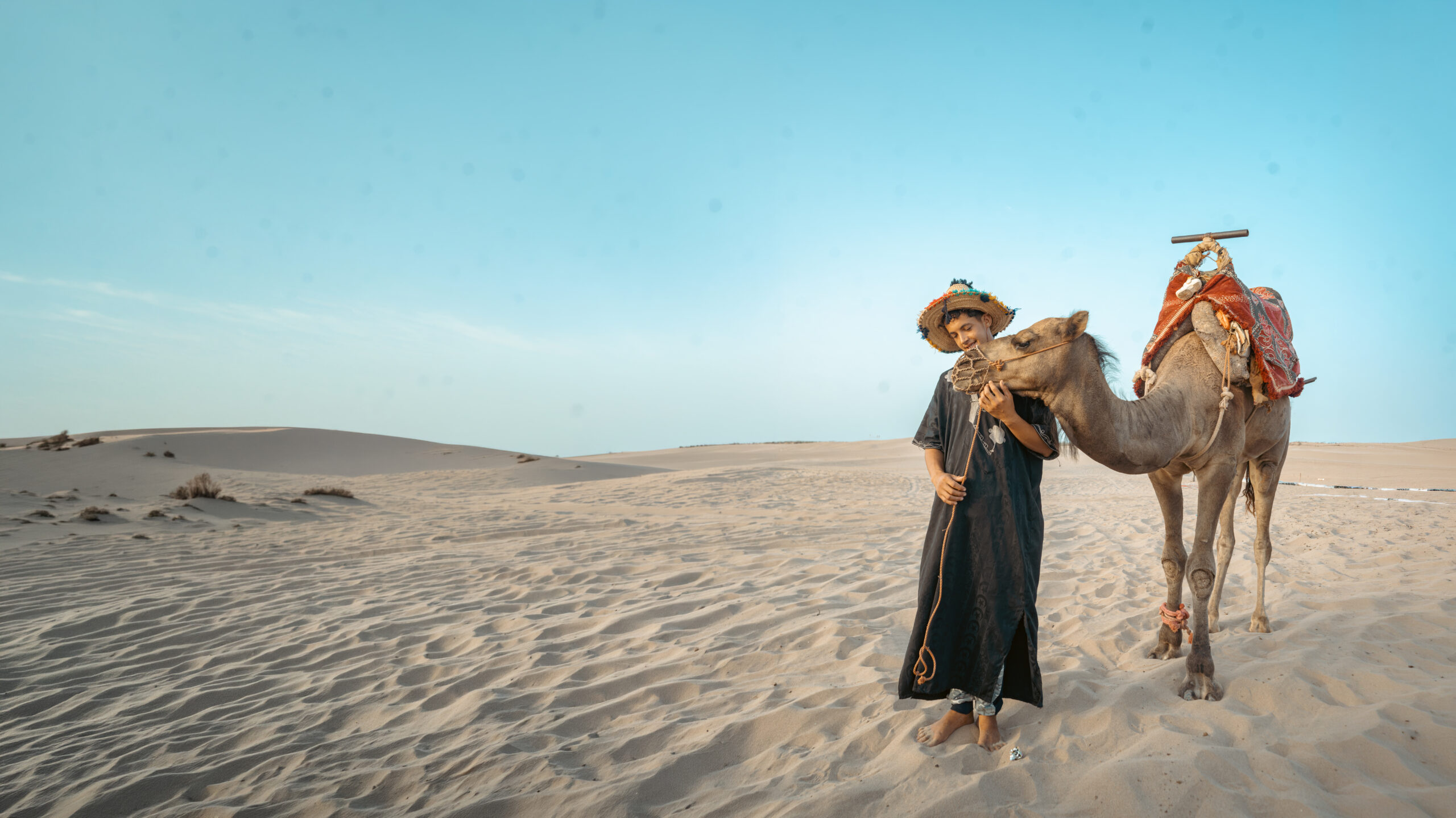 Camel riders crossing an open landscape